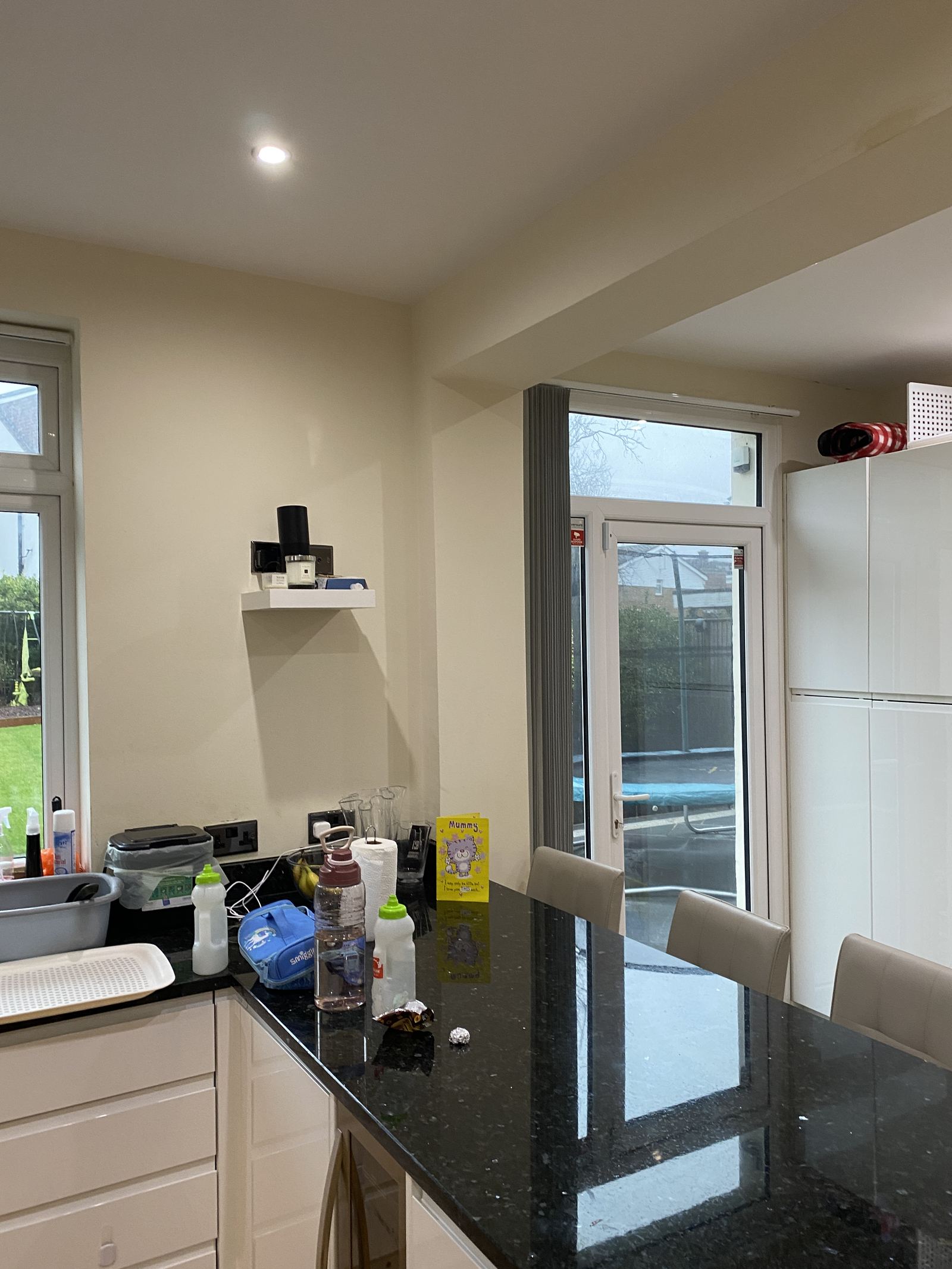 The kitchen before the work, with a breakfast bar and a single door to the garden