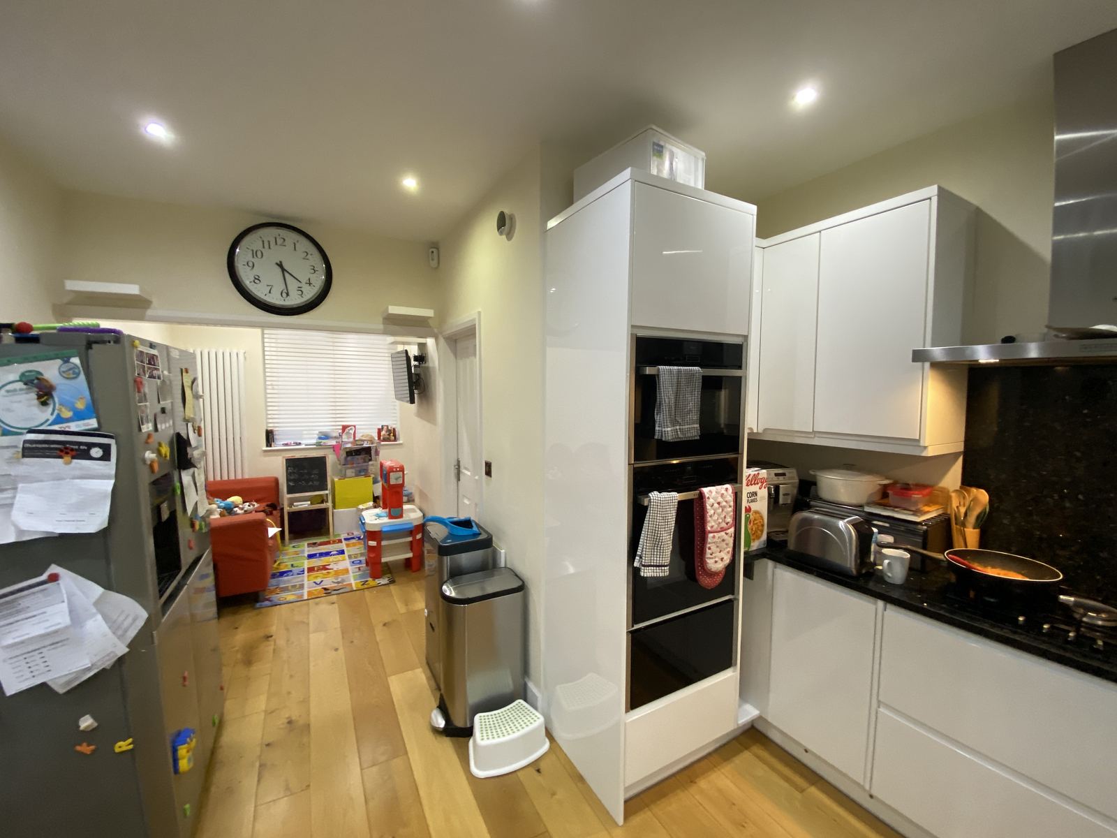 The existing kitchen looking through a doorway to a small back room used as a playroom