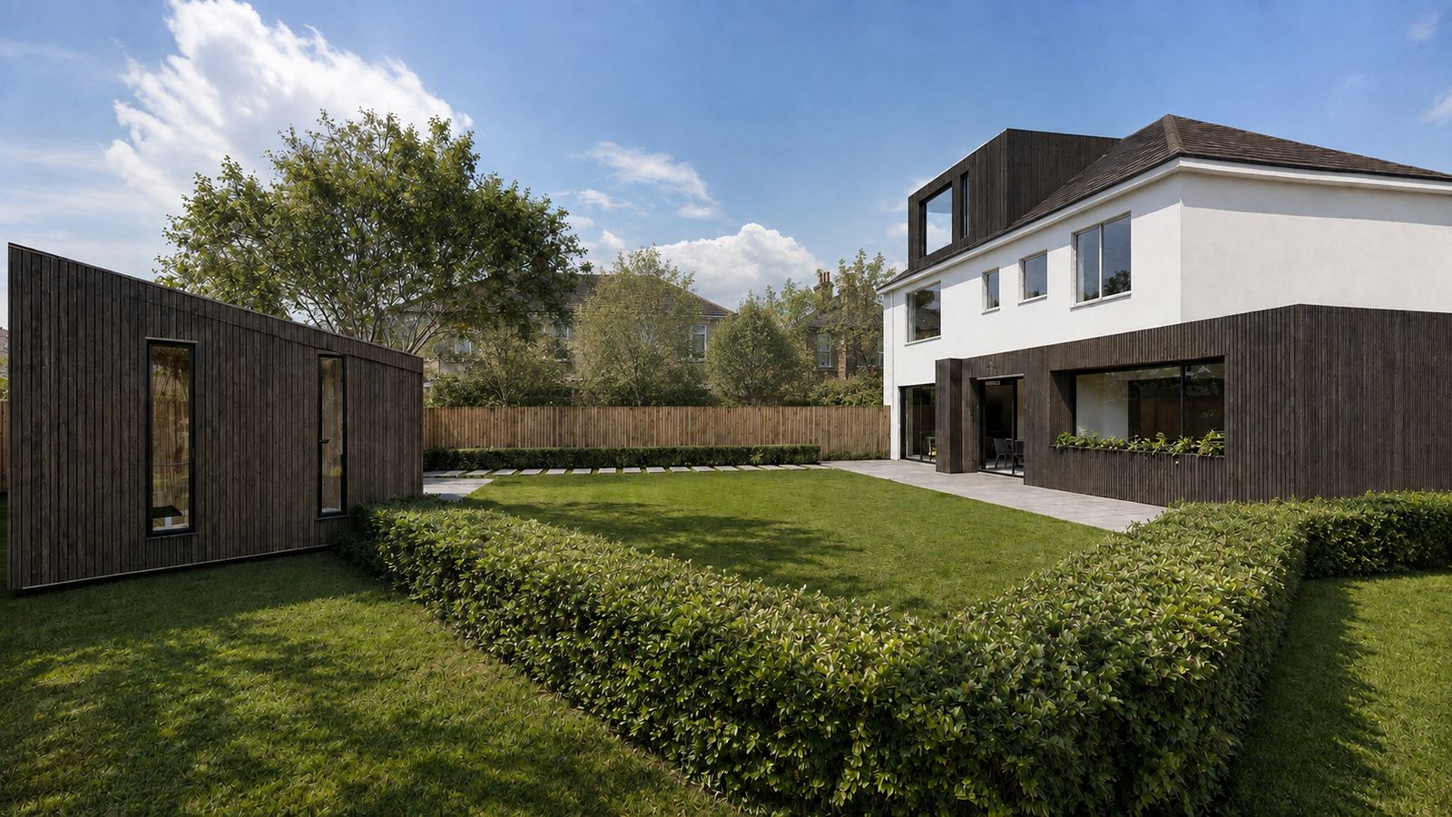 The rear extension and the garden pod across the lawn, both clad in dark timber