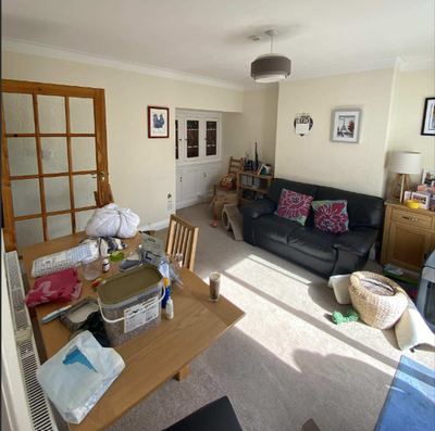 The family living space before the work, with a sofa, dining table and a glazed internal door