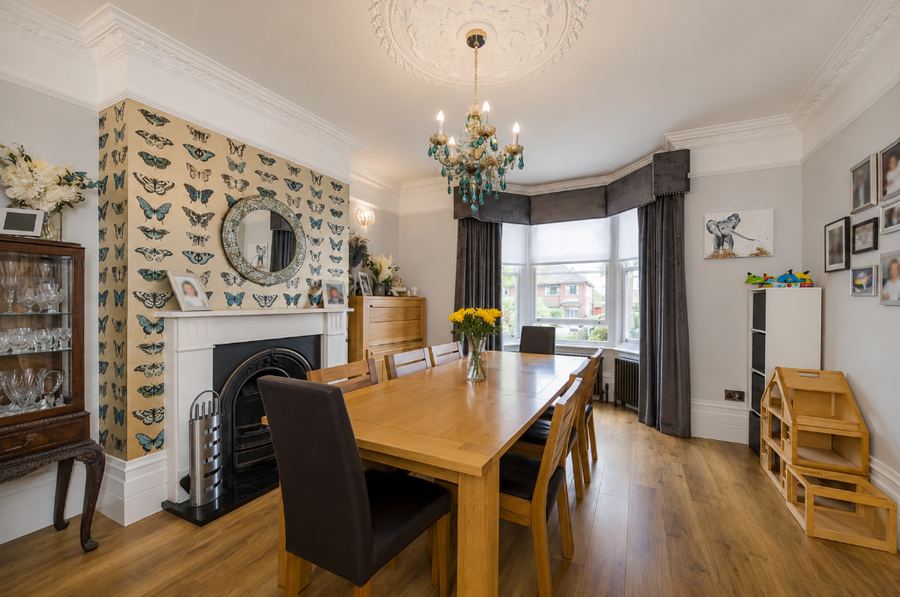 The room that became the living room, as the house was marketed, laid out as a dining room with a butterfly-papered chimney breast