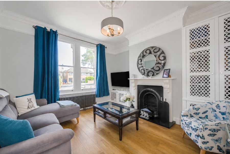 The media room as the house was marketed, a pale front room with a television over the fireplace