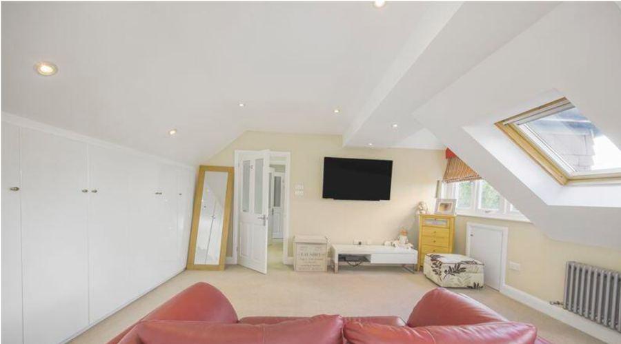 The attic bedroom before the work, looking towards the door past a run of white fitted wardrobes